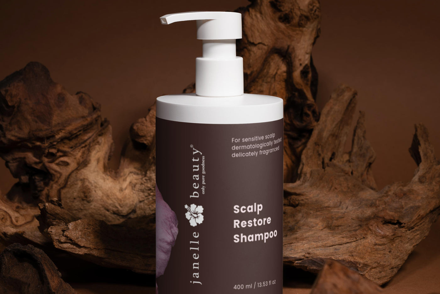 Shampoo bottle labeled 'Scalp Restore Shampoo' by Janella Beauty on a brown background with wood.